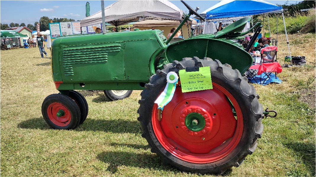 a green tractor with orange wheels
