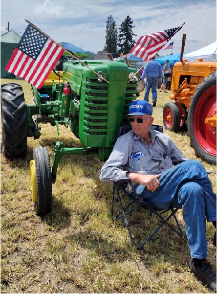 a man sitting in front of his old tractor